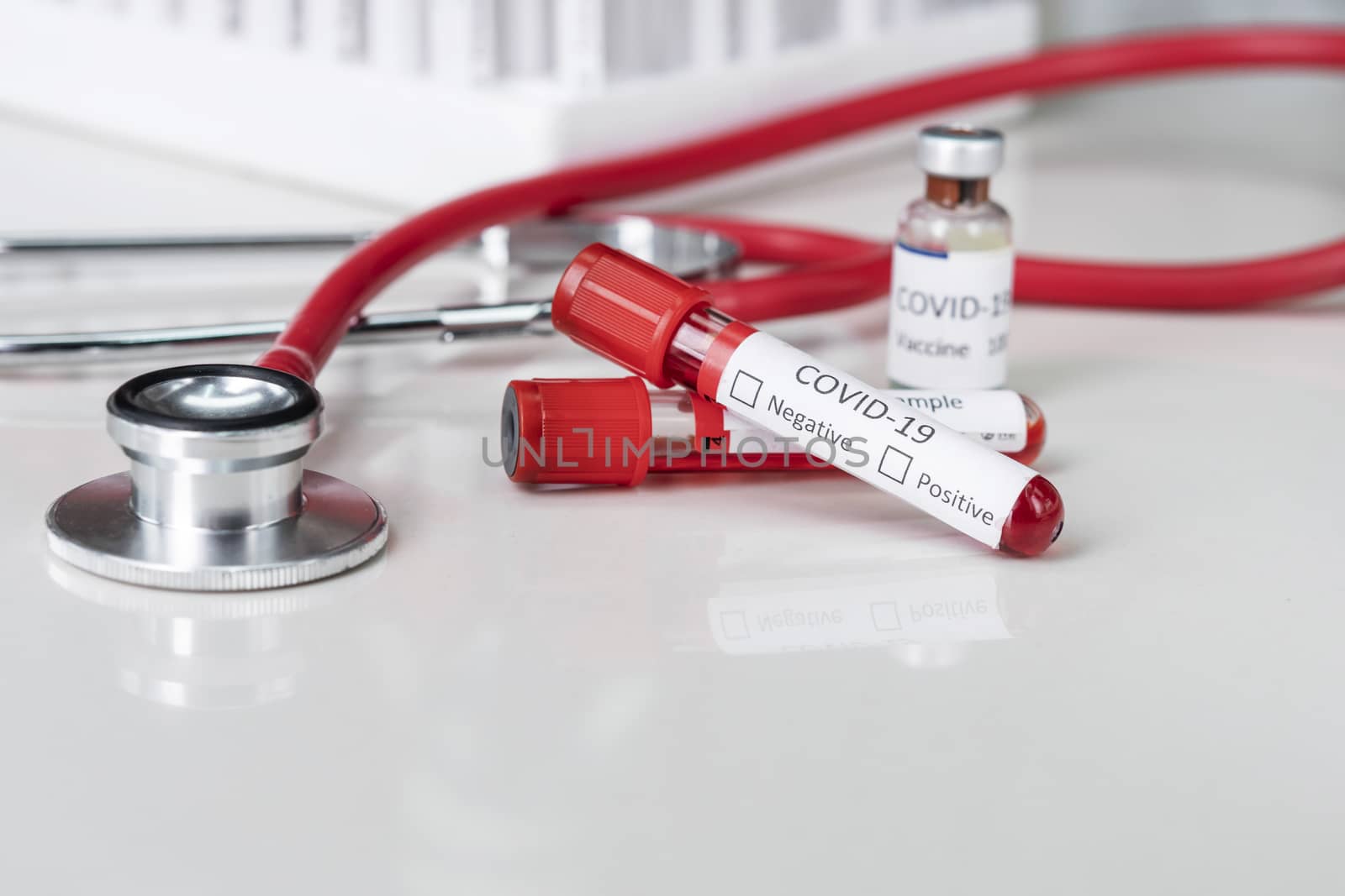 Stethoscope and blood sample vacuum tube. Covid-19 or Coronavirus Concept, Biological blood samples in test tubes and vaccine for the disease and syringe injection on a table. Laboratory test.