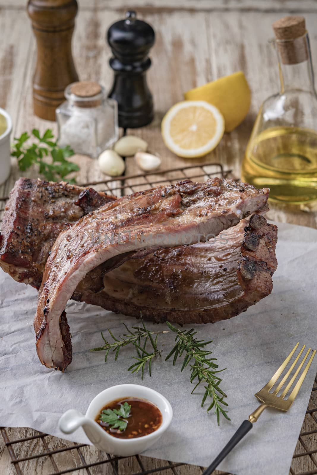 Grilled pork ribs with mashed potatoes placed on a wooden table.