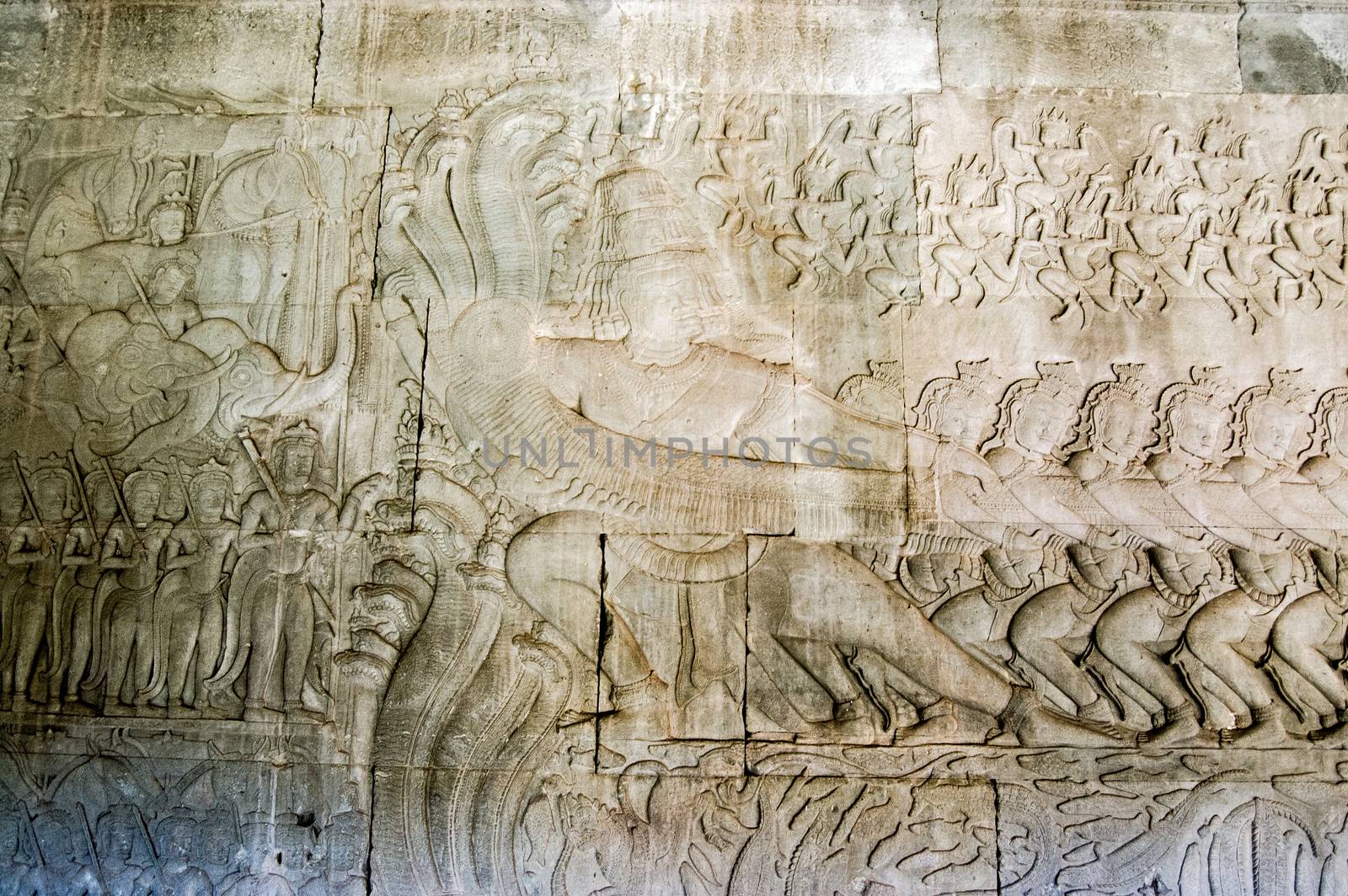 Historic Khmer carving showing the demons pulling on the sacred multi-headed snake known as Vasuki. Hindu legend, the Churning of the Ocean of Milk, bas relief at Angkor Wat temple, Cambodia.