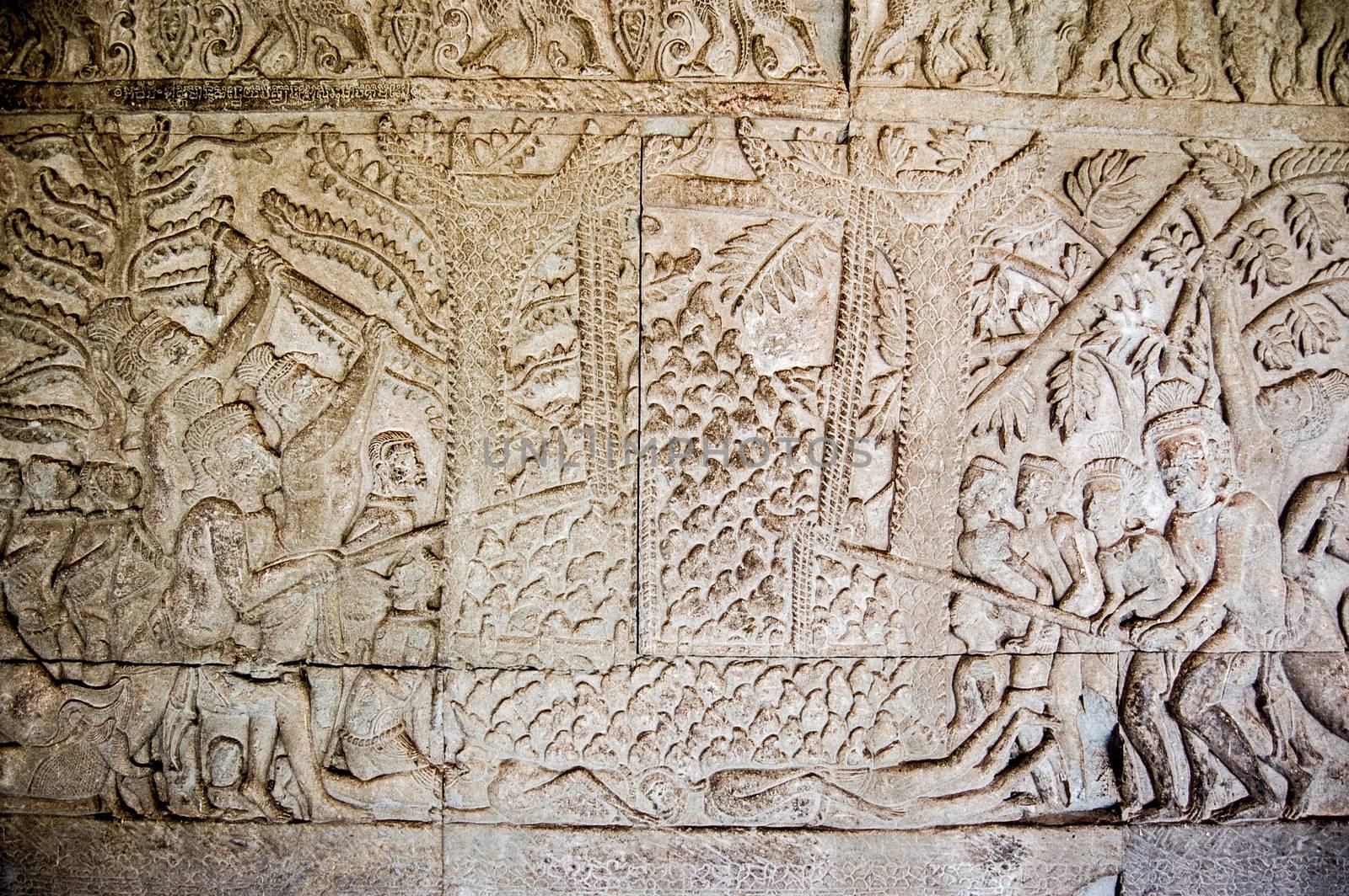 Bas relief carving showing one of the 32 hells of Hindu religion. Rice thieves are punished by demons sticking red hot irons thrust through their abdomens. Angkor Wat temple, Siem Reap, Cambodia.