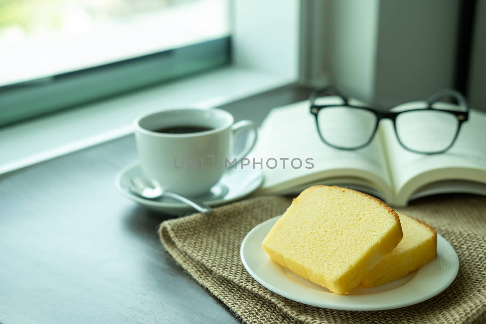 Snacks in the morning break. There are butter cakes, coffee on the table next to the window of the weekend by Toefotostock