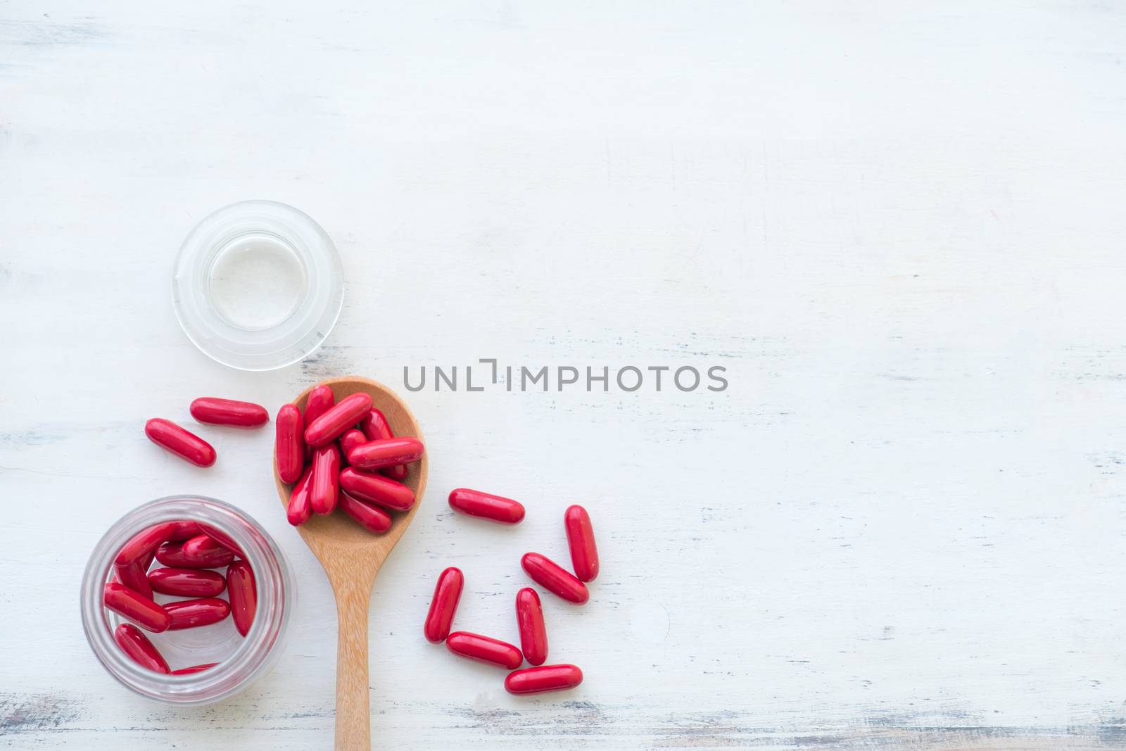 Top view Variety of vitamin and mineral pills in wooden spoon on by Toefotostock