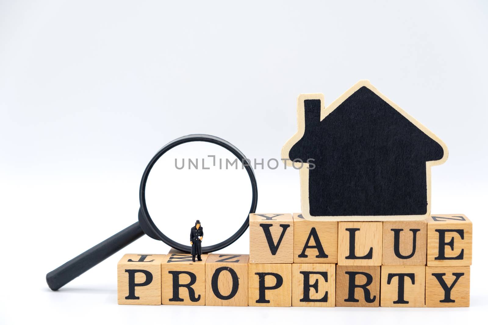 miniature of detective on Wooden blocks with the word Value Property and the house with a magnifying glass.