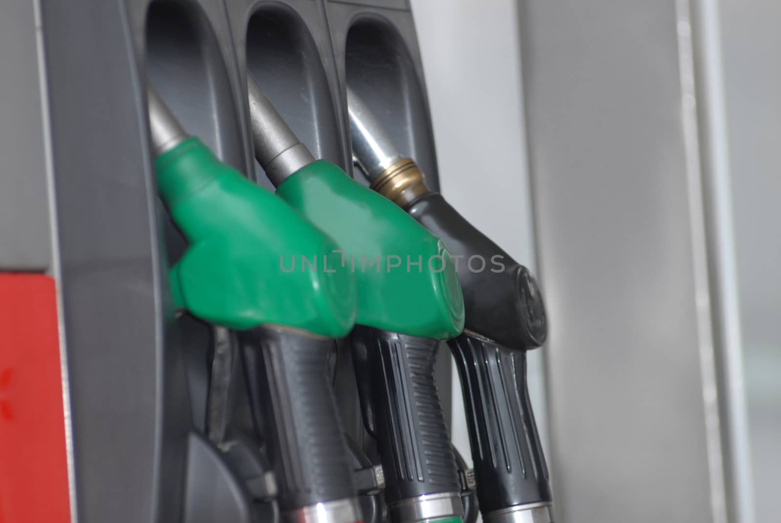 Three Gas pump nozzles on the petrol station