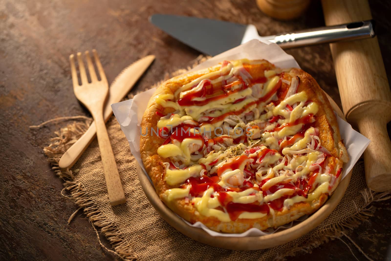 Close up of tasty homemade seafood topped pizza fusion food style on wooden tray.