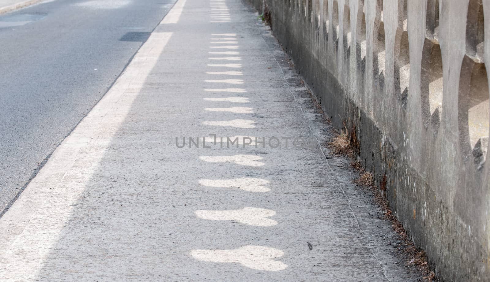 rude shapes on pavement caused by light shinning through by sirspread