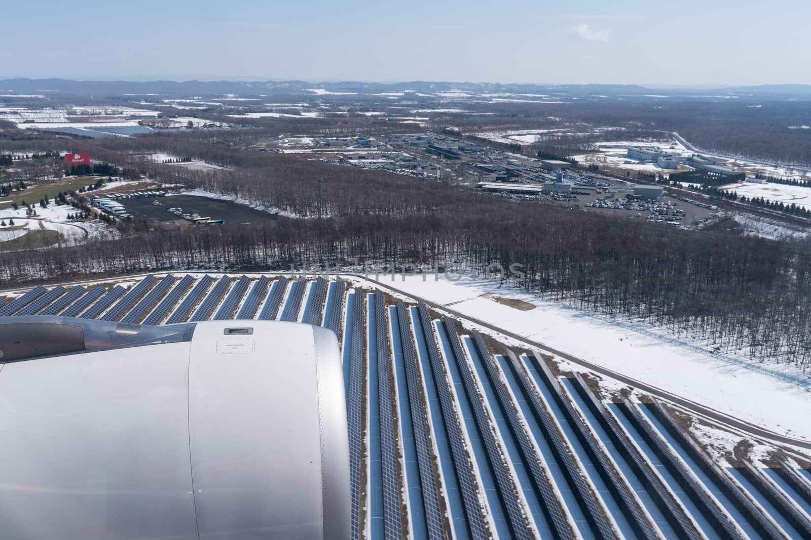View of beautiful solar cell farm covered by snow from a airplane window.