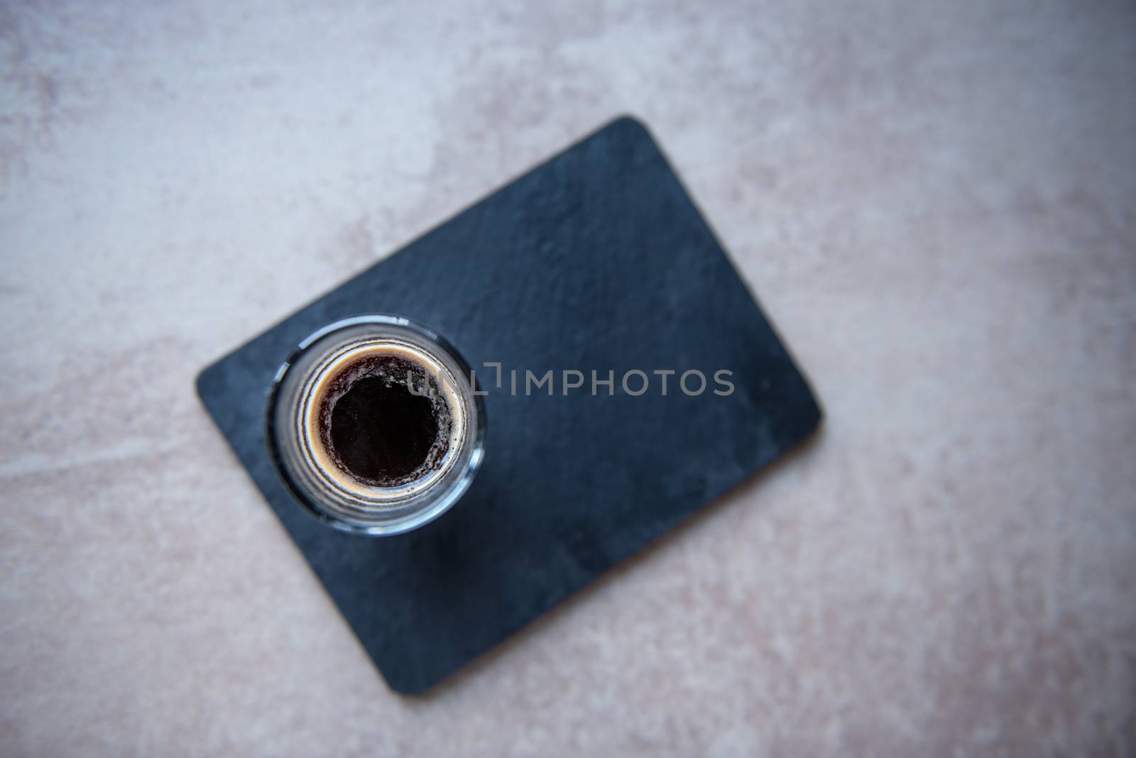 Top view on glass cup of espresso on black board