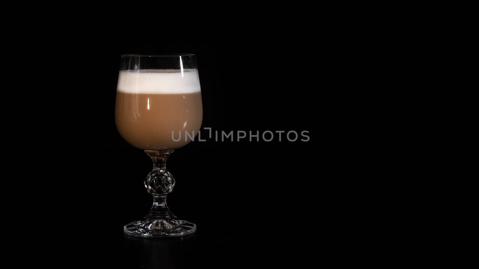 multilayer coffee or cappuccino in a glass cup on black background