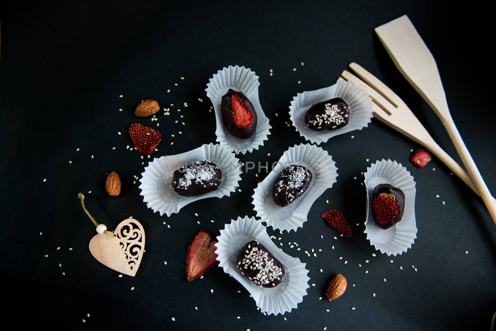 Top view of set handmade fruit and chocolate candies on a black background by marynkin