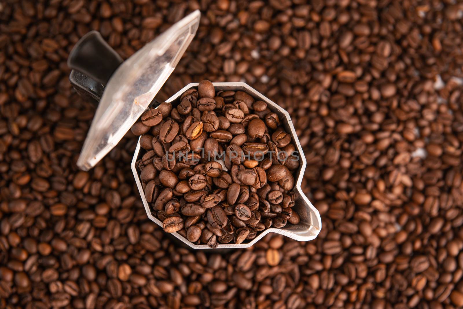 coffee beans in mocha pot on coffee beans background by marynkin