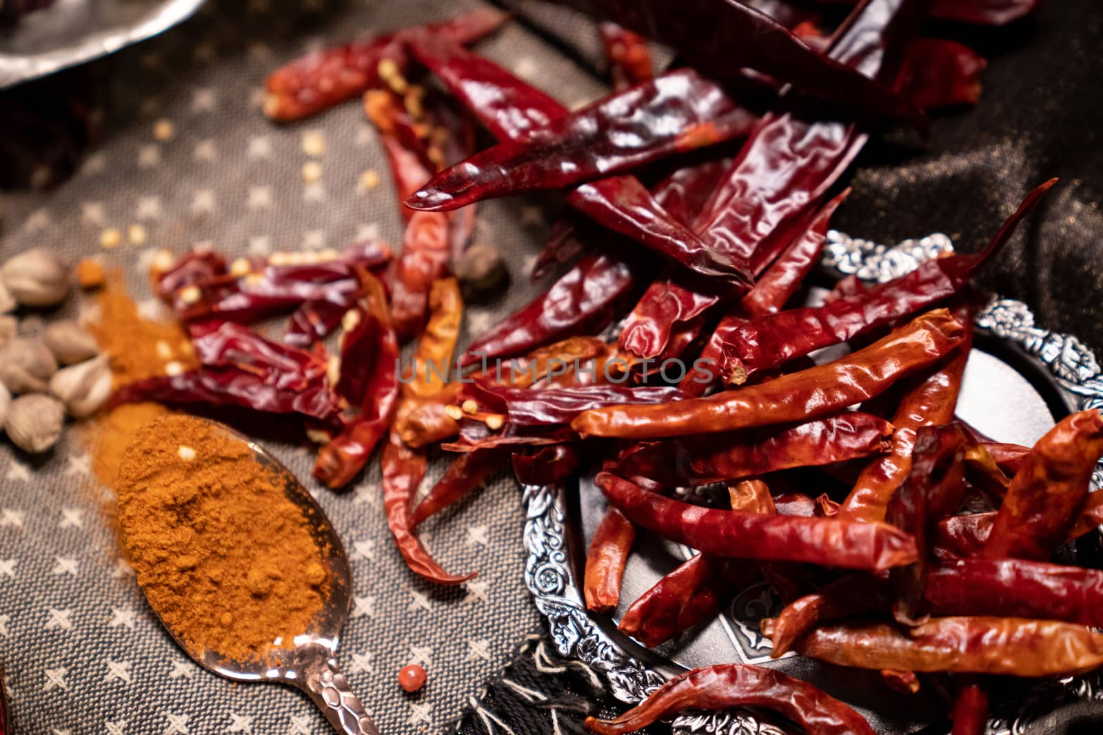 Dry red chillies and dried chilli powder on spoon.