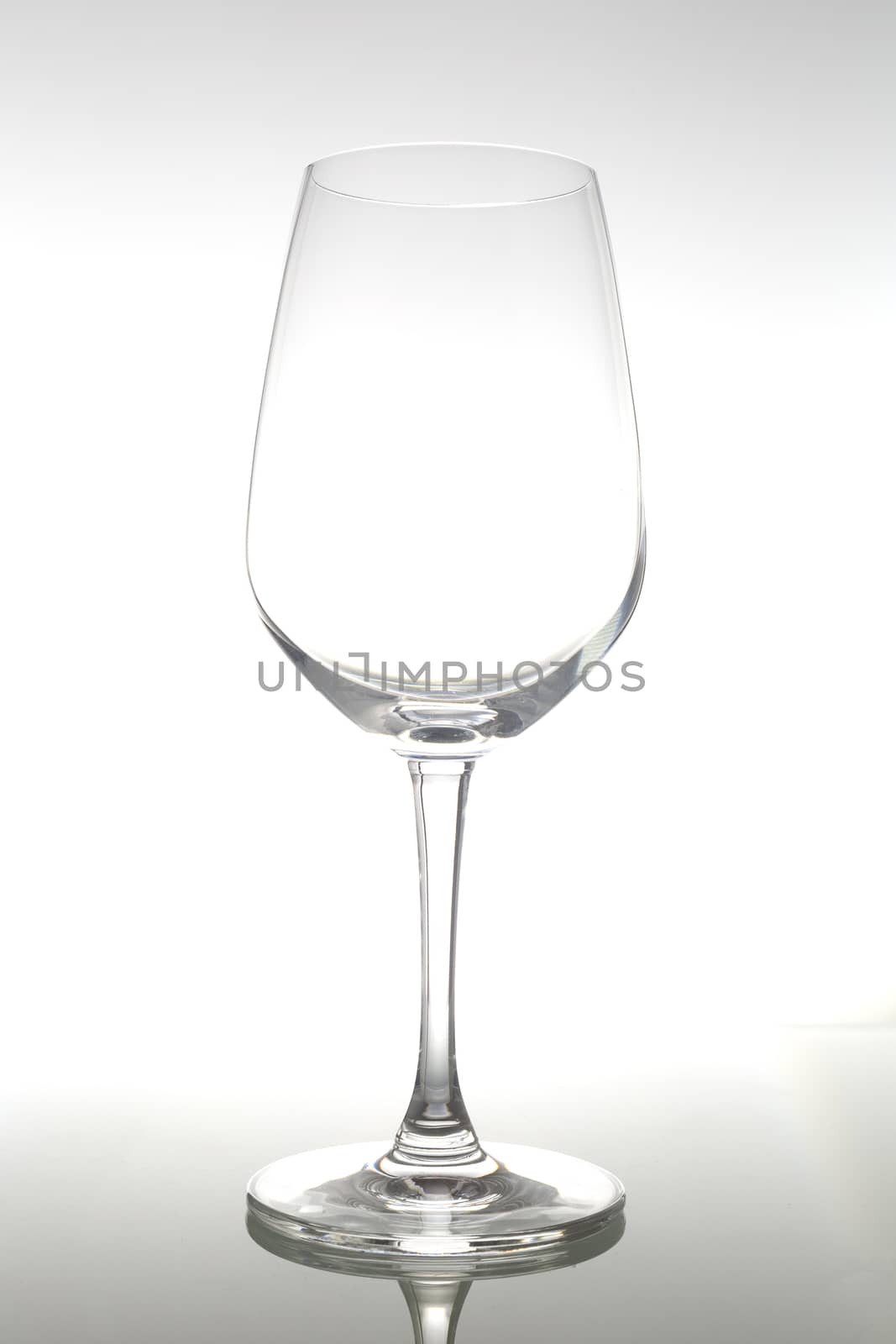 Empty wine glass on glass table. Empty glass on white background.