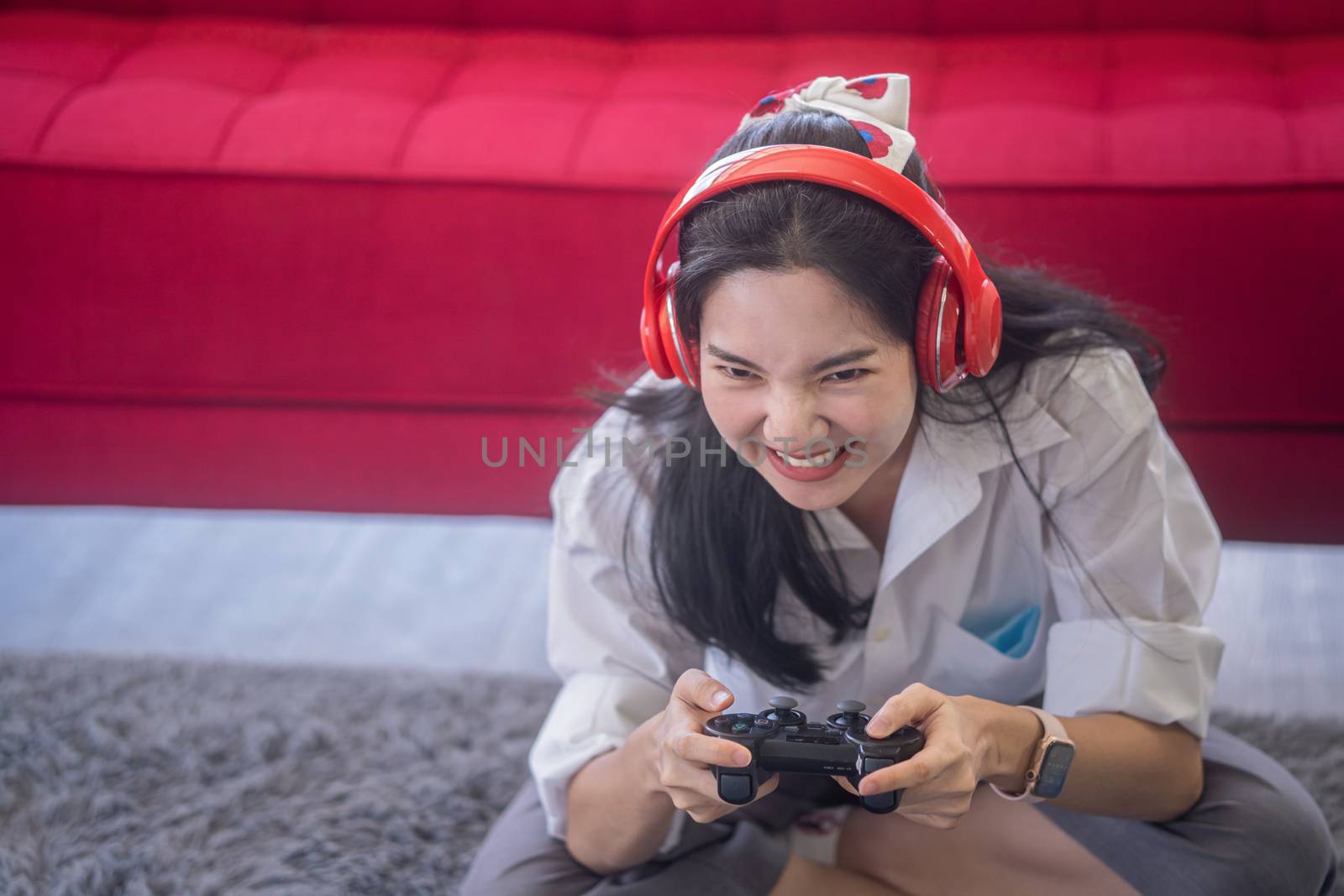 young asian woman enjoy her media gaming in the living room by sandyman