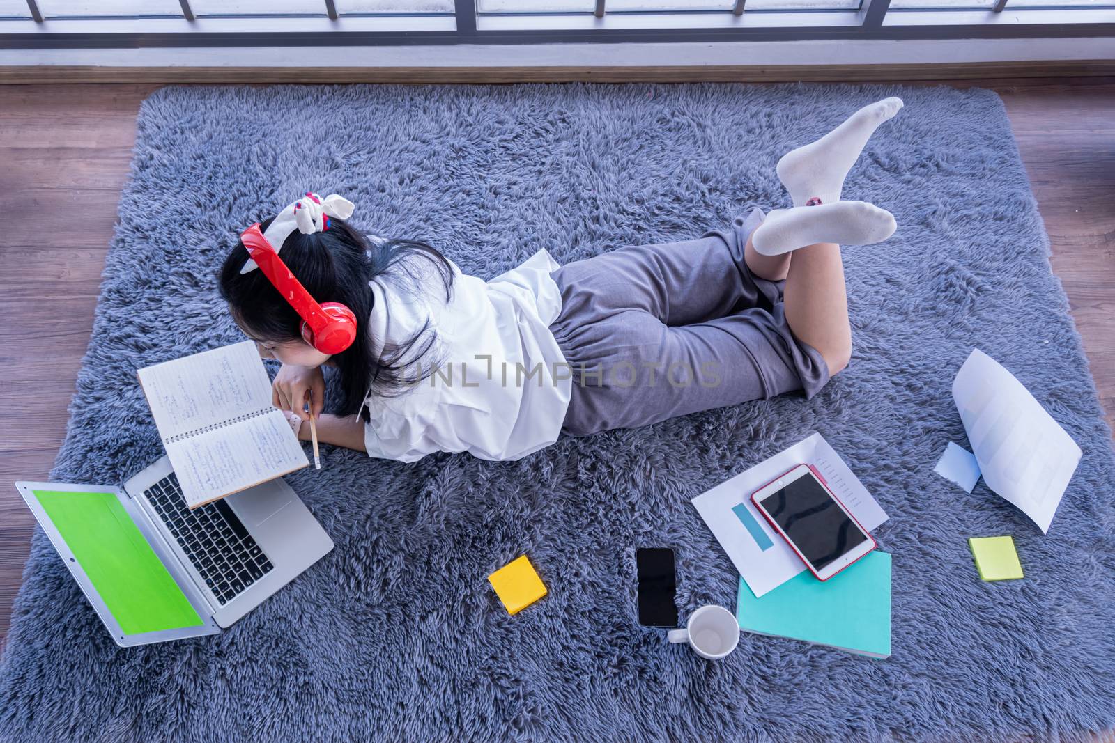 top view of young asian woman working with laptop computer in the living room. Work from home and study at home concept.