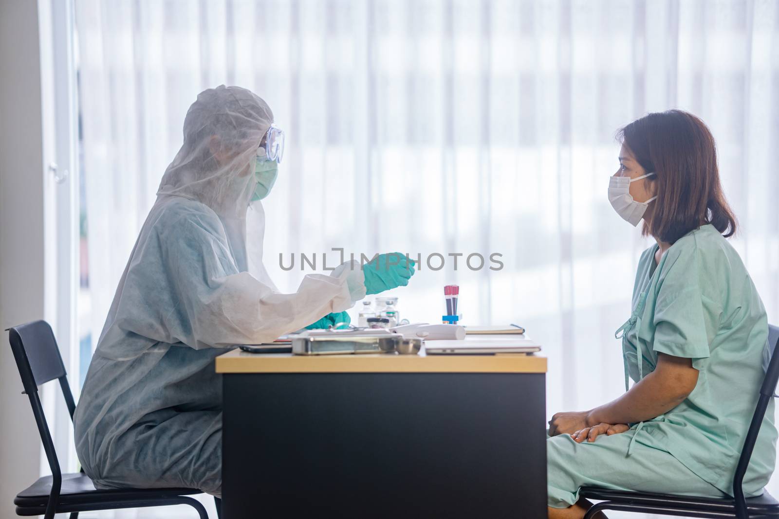 Asian Female Patient Being Reassured By Woman Doctor In Hospital by sandyman