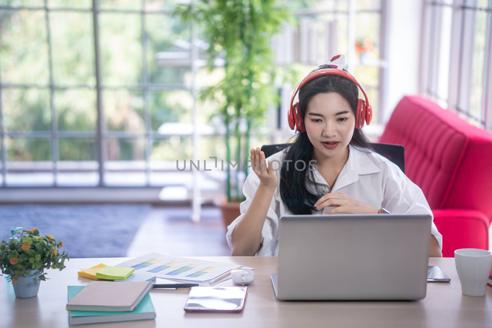 top view of young asian woman working with laptop computer in the living room. Work from home and study at home concept.