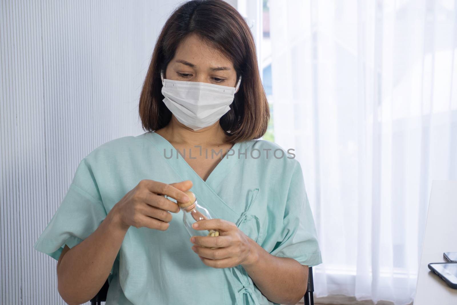 old asian patient wear surgical mask looking to drug bottle , she admit in hospital, she want to pollution protection and virus protection, elderly healthcare and infection control, corona virus