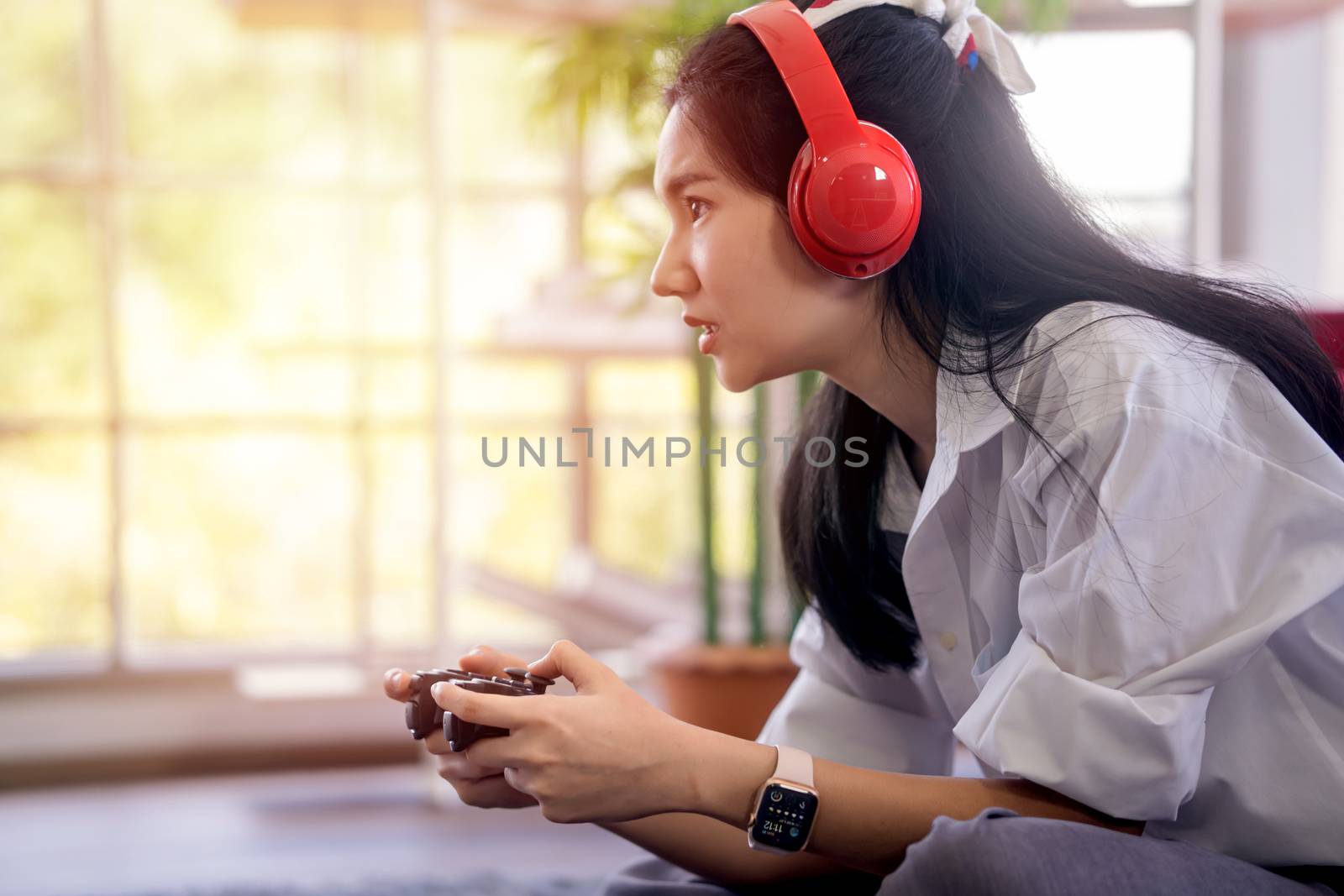 young asian woman enjoy her media gaming in the living room by sandyman