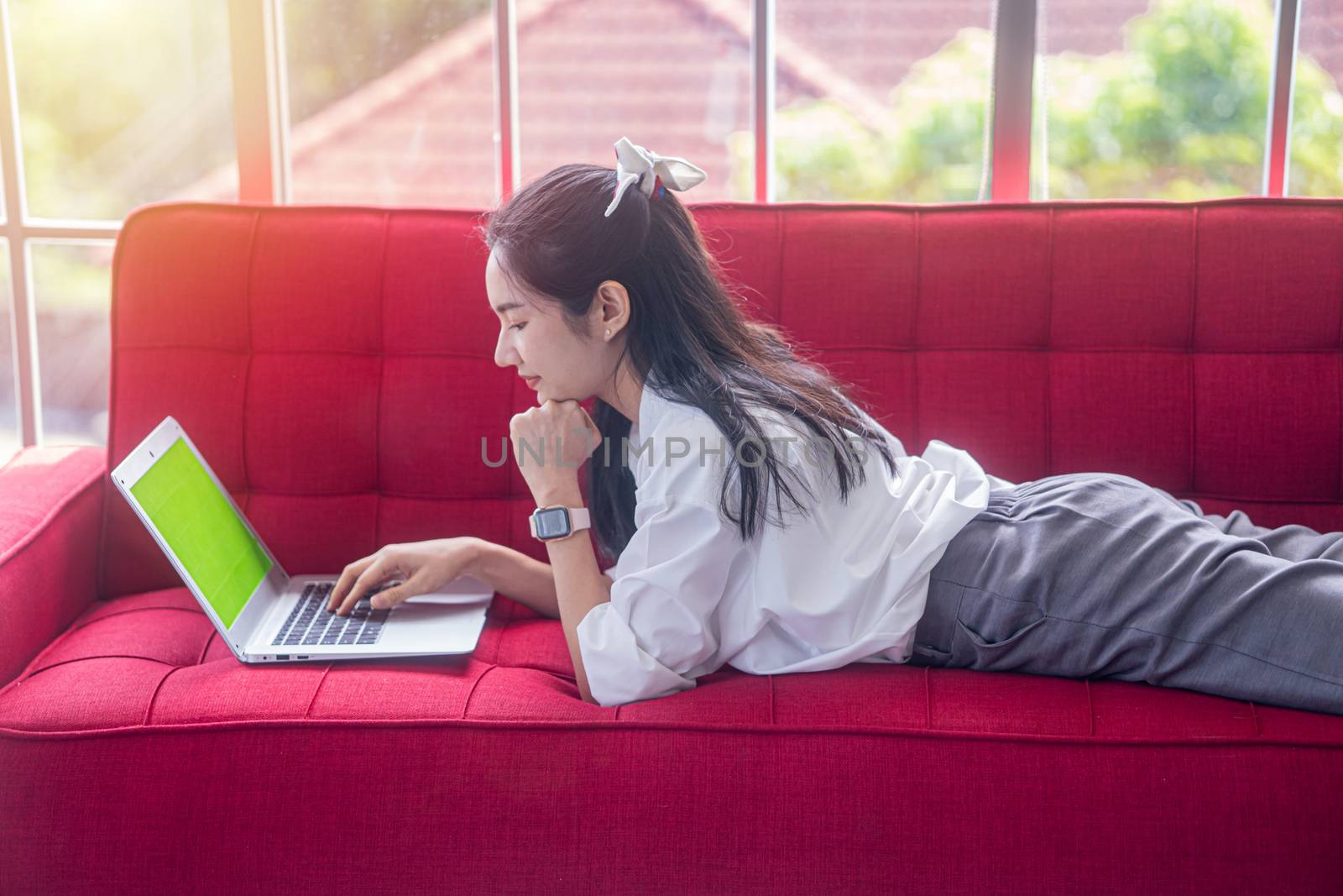 top view of young asian woman working with laptop computer in the living room. Work from home and study at home concept.