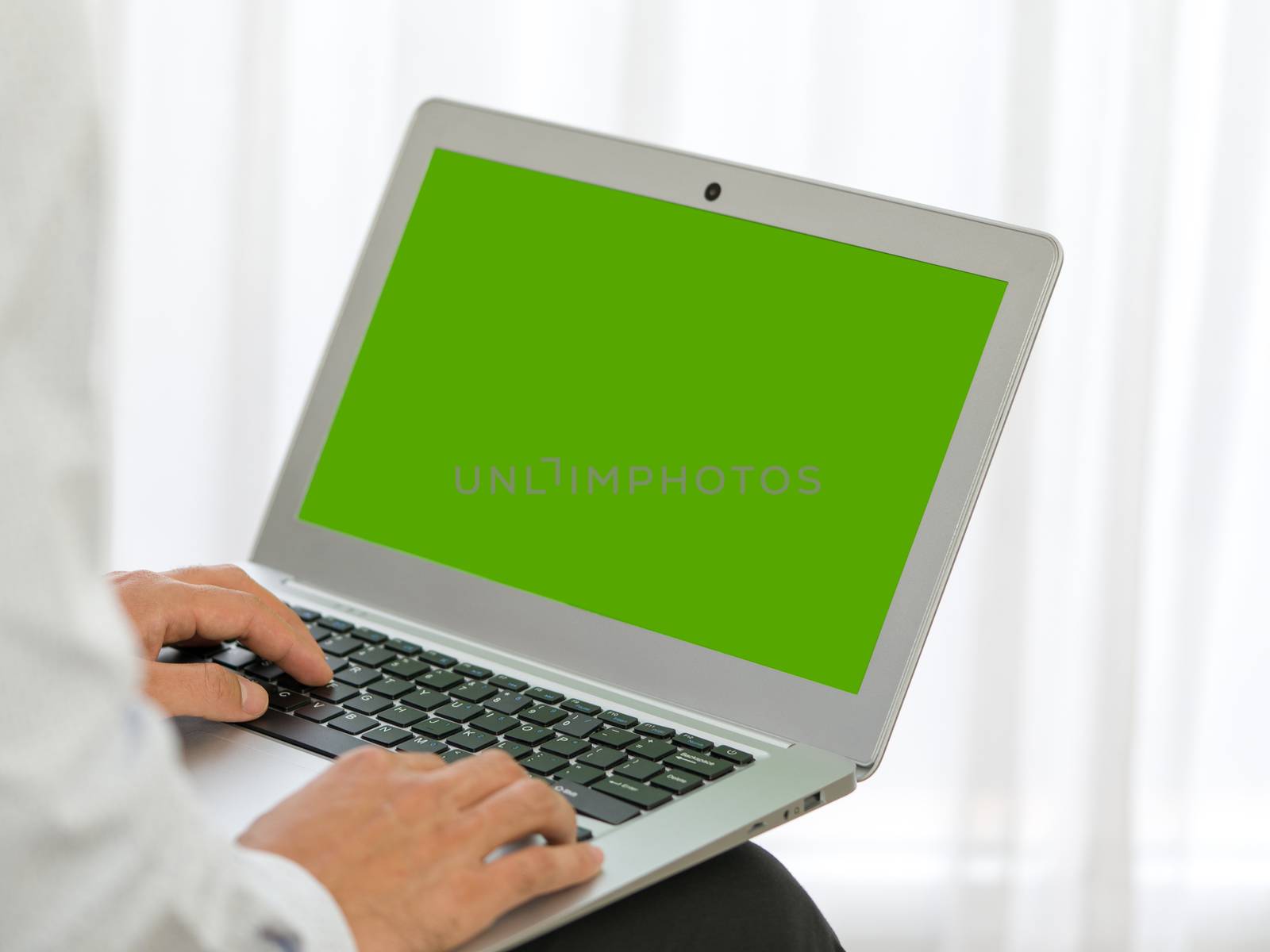 Business man hands typing on laptop computer with green screen. by chadchai_k