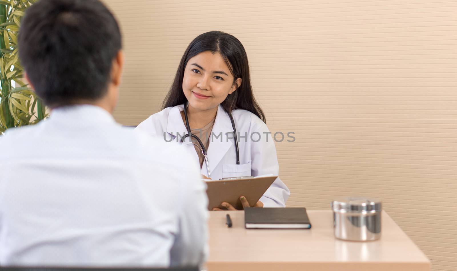 Female doctor meeting with a patient in the office, she is giving a prescription to the man, healthcare and medicine concept