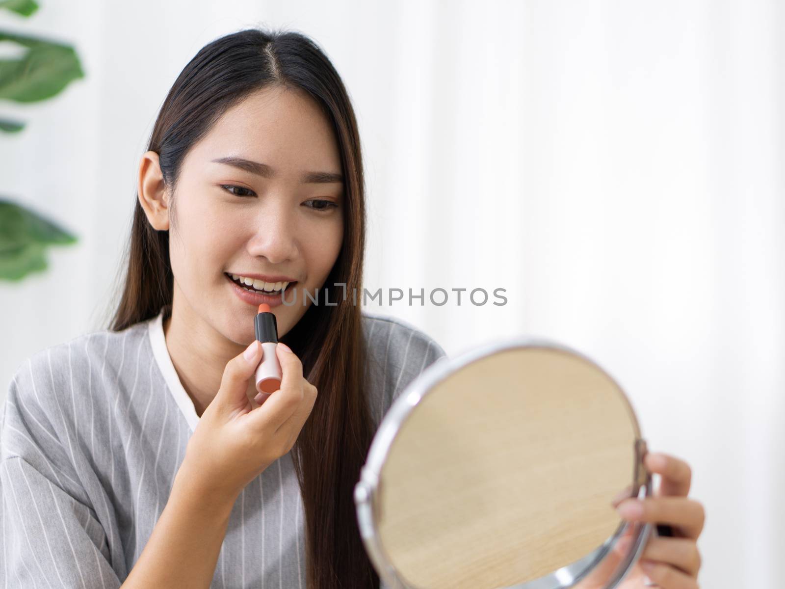 Young asian teen have fun learning to make-up in her room, enjoy leisure weekend at home.