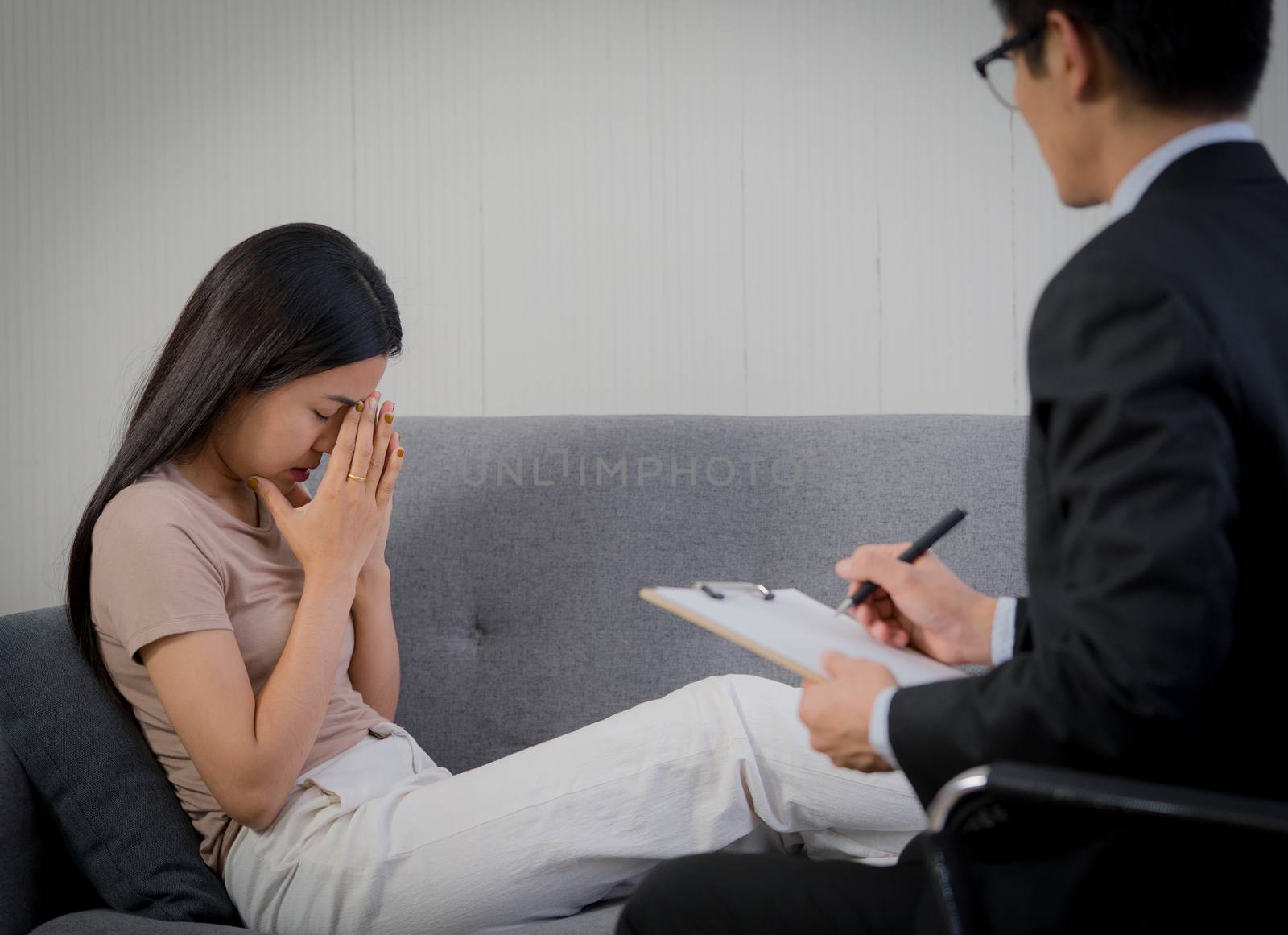 Sad woman with depression having consultation with psychiatrist in hospital mental health service center