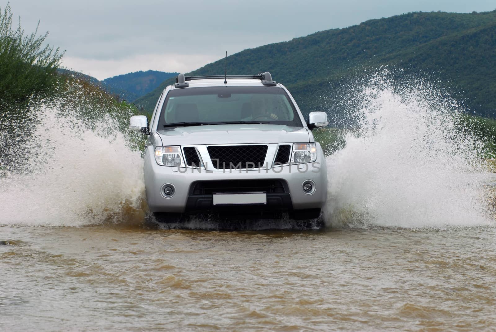 Suv splash on the river outdoor, traveling on the road