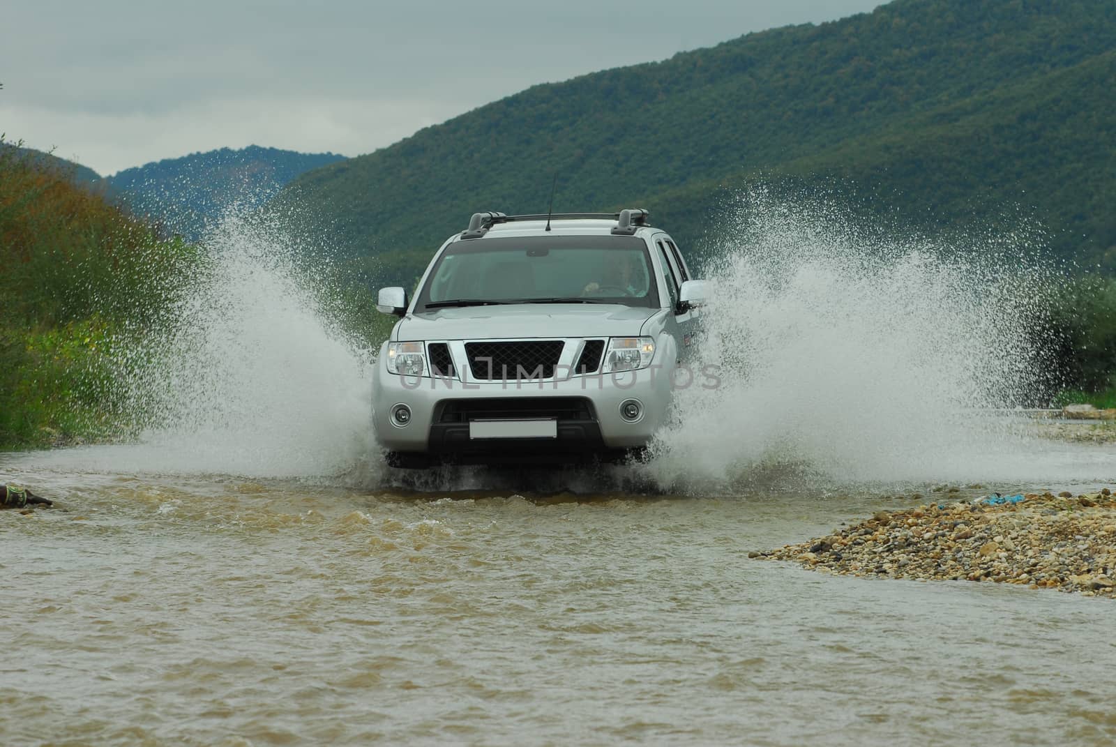 Suv splash on the river outdoor, traveling on the road