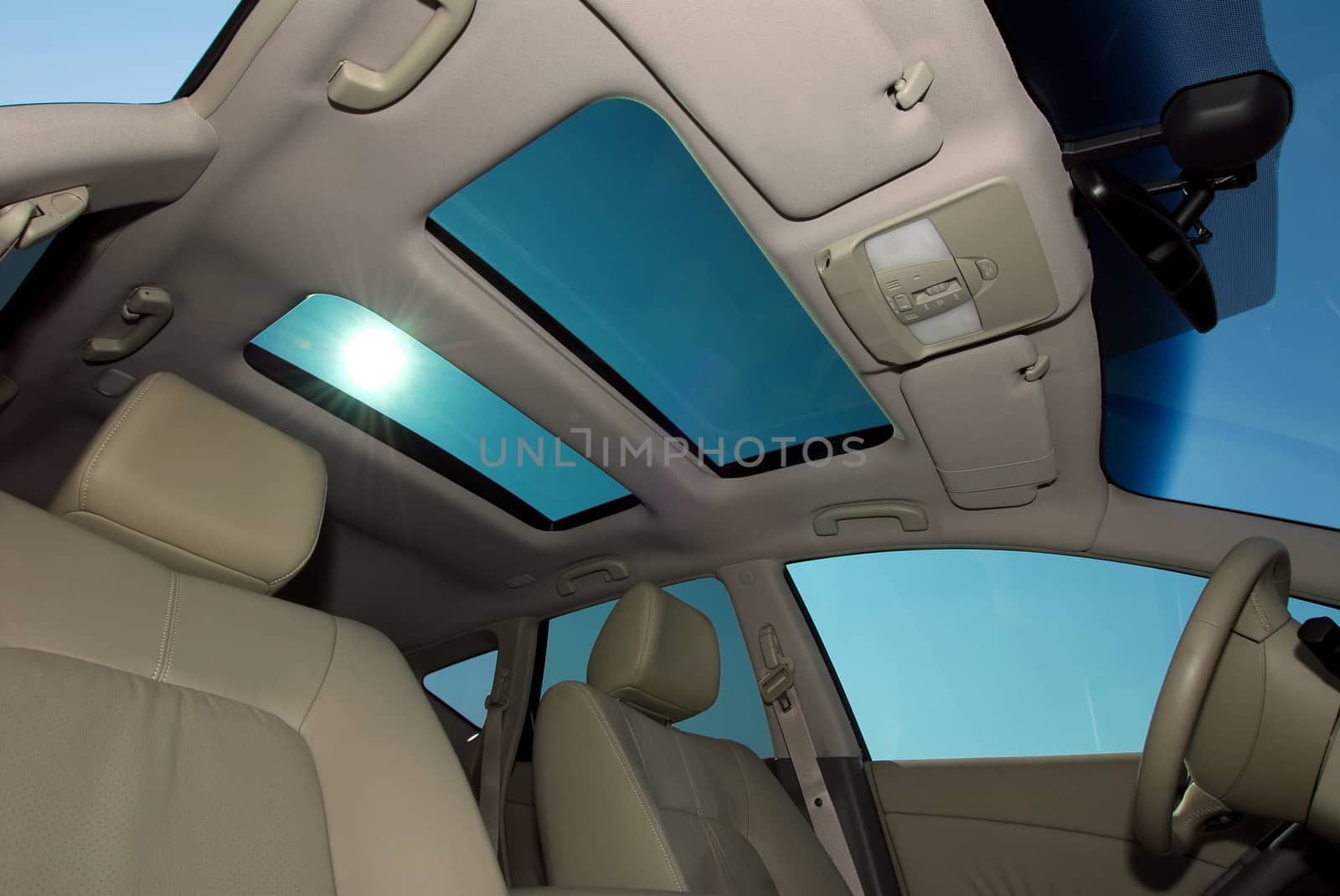 detail in the interior of a modern luxury car, photo large sunroof inside car, sky and clouds