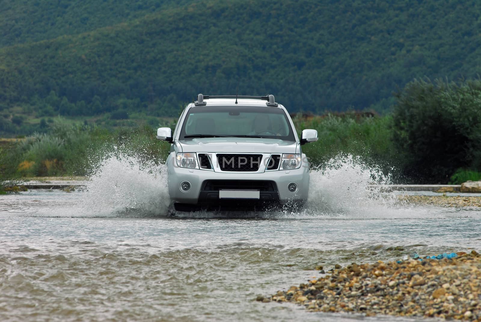 Suv splash on the river outdoor, traveling on the road