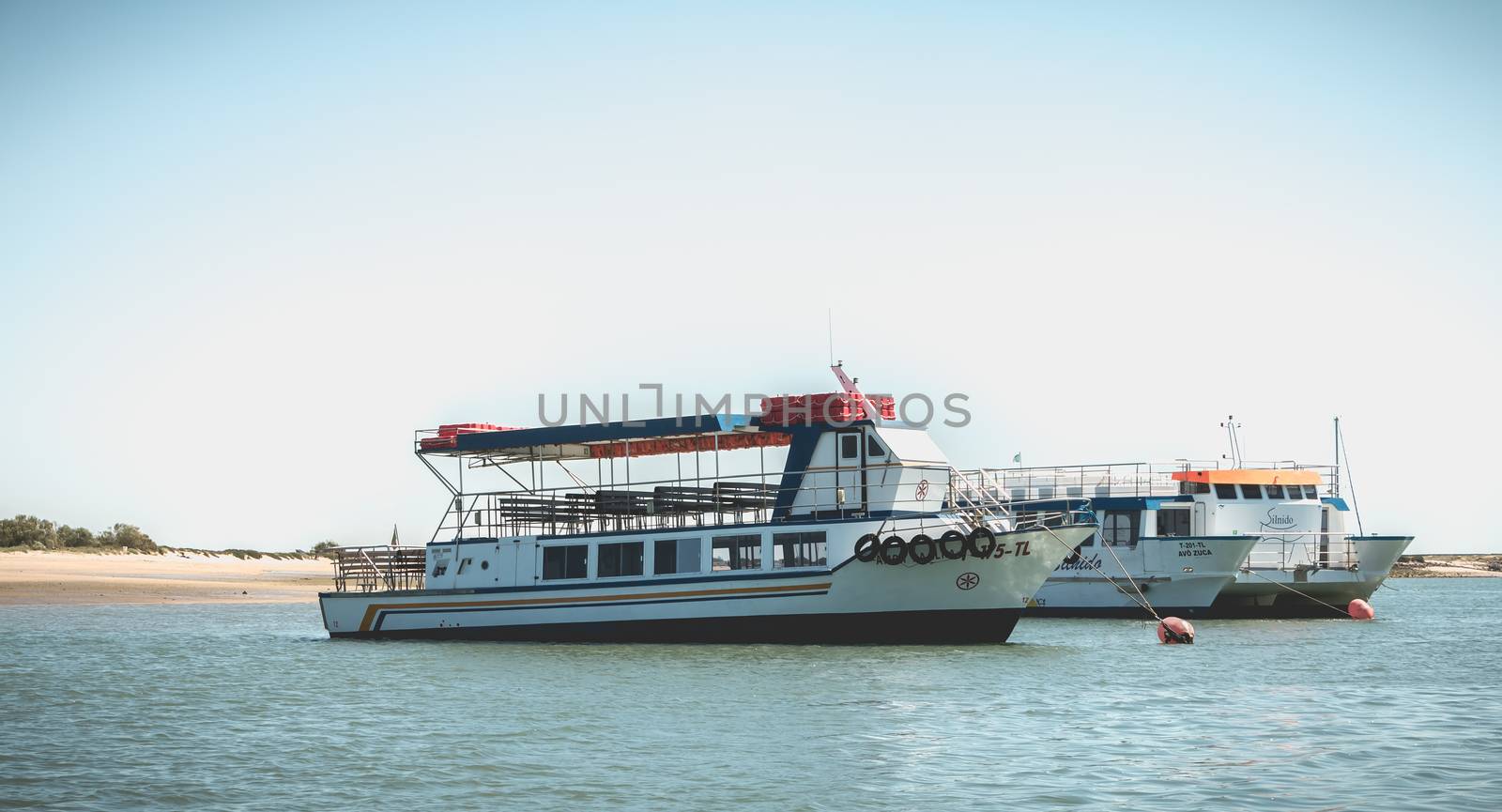 Tavira, Portugal - May 3, 2018: Tourist transport boats moored in the lagoons of the Ria Formosa Natural Park near the port of Tavira on a spring day