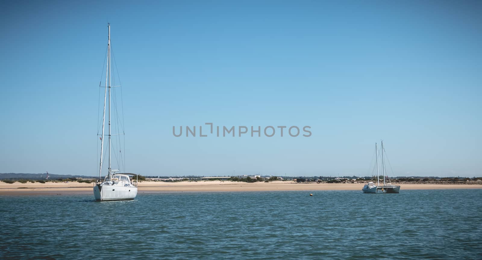 Tavira, Portugal - May 3, 2018: Sailing boat moored in the lagoons of the Ria Formosa Natural Park near the port of Tavira on a spring day