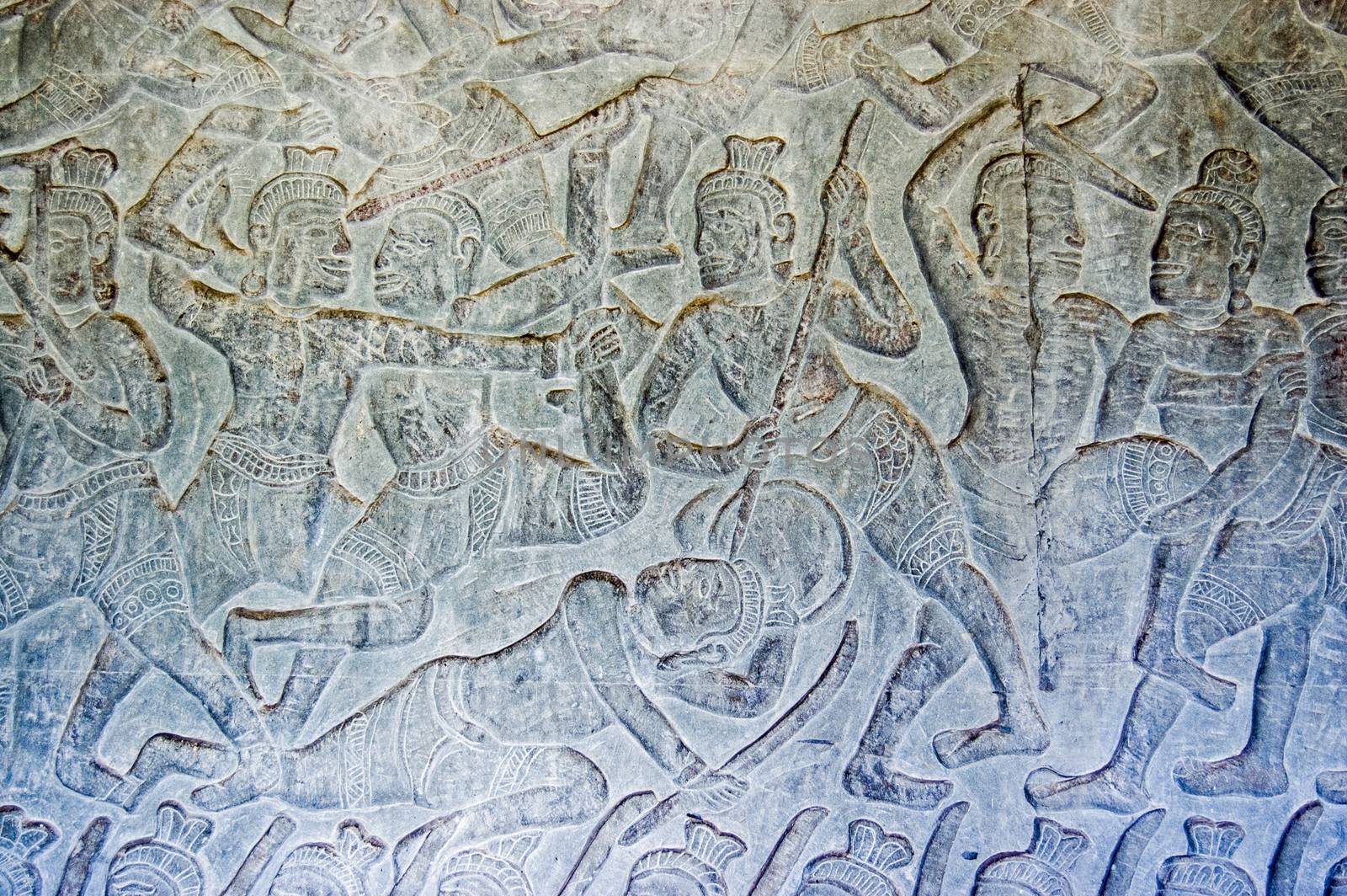 Ancient Khmer bas relief carving showing a battle with a soldier killed with a spear. Angkor Wat temple, Siem Reap, Cambodia