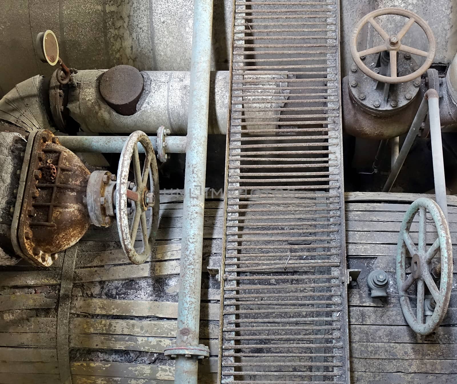Old rusting machinery and valves in an abandoned factory