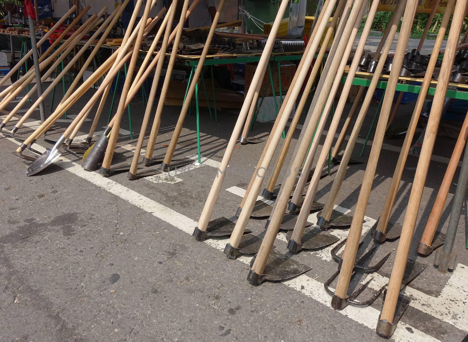 A street vendor sells handcrafted agricultural and gardening tools
