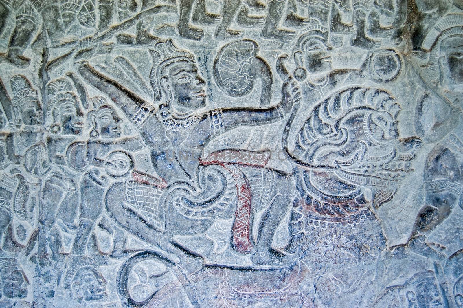 A warrior armed with a sword in battle while riding a Chinese lion. Bas relief carving in the Vishnu and the Asuras gallery, Angkor Wat temple, Siem Reap, Cambodia.