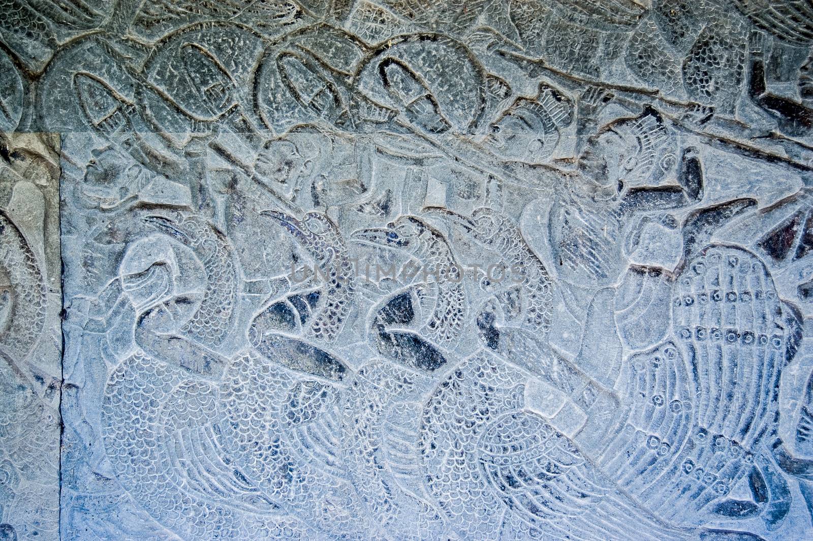Bas relief carving showing soldiers riding into battle on the backs of peacock birds.  Exterior wall of the historic Angkor Wat temple in Siem Reap, Cambodia.