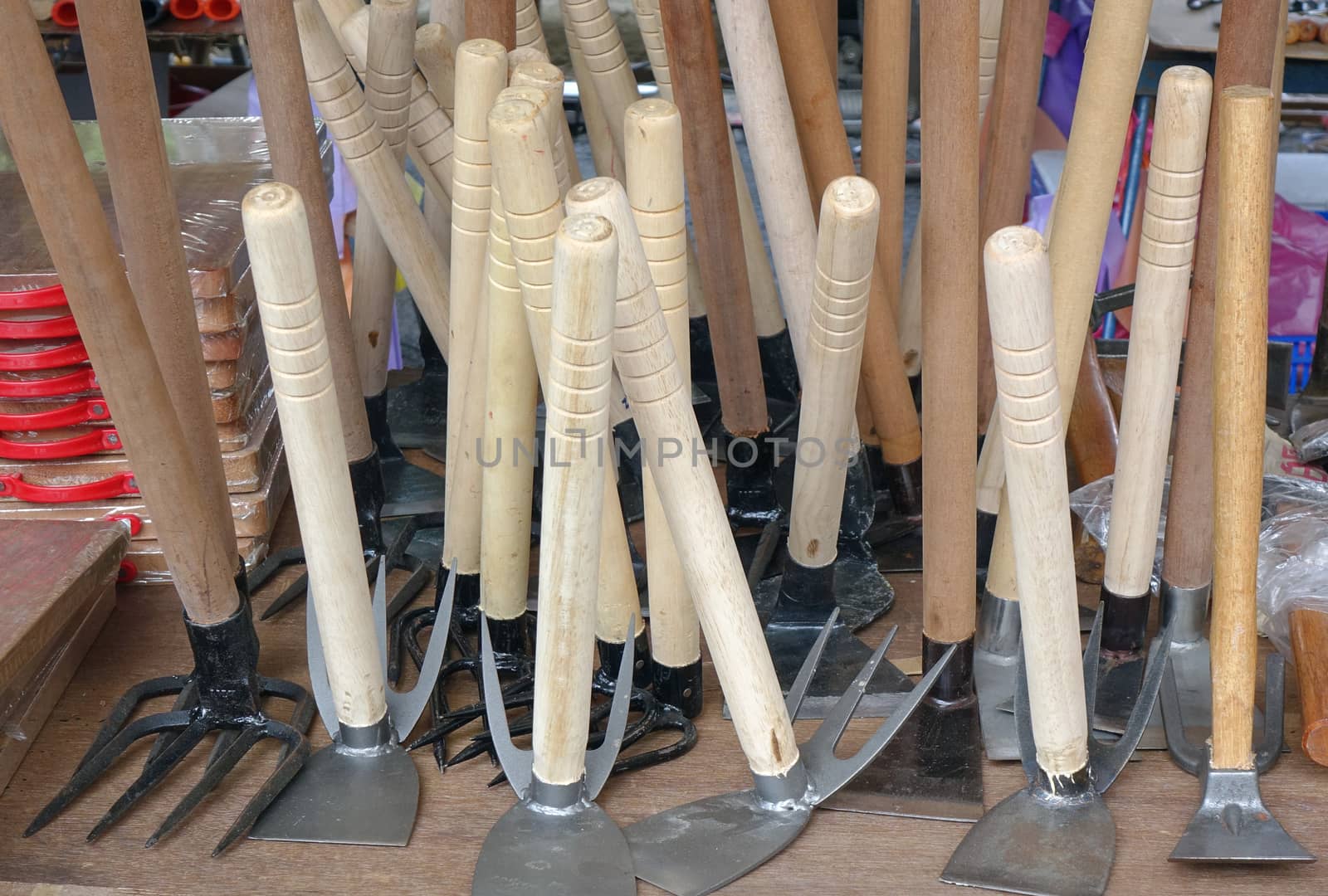 A street vendor sells handcrafted agricultural and gardening tools