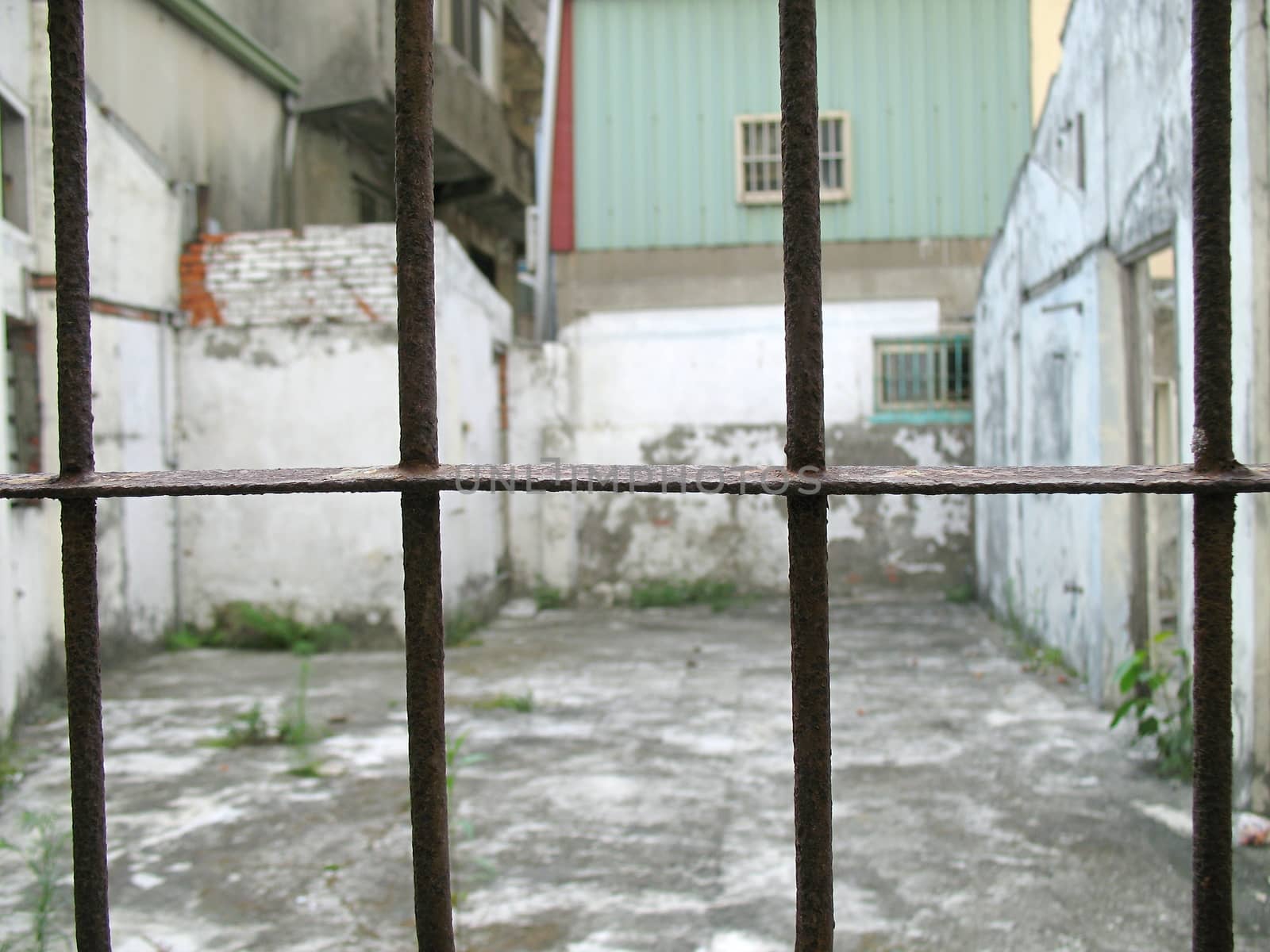 Old rusty iron bars that are part of a deserted, broken house
