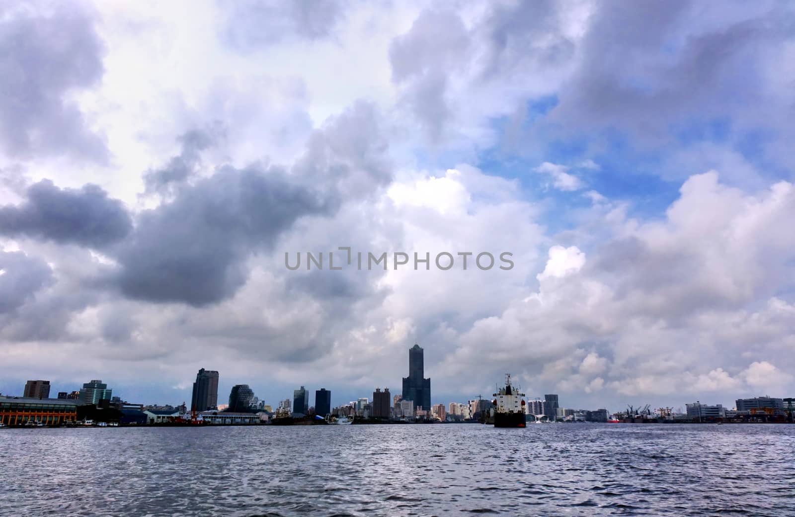 The skyline of Kaohsiung city and port under a dramatic sky
