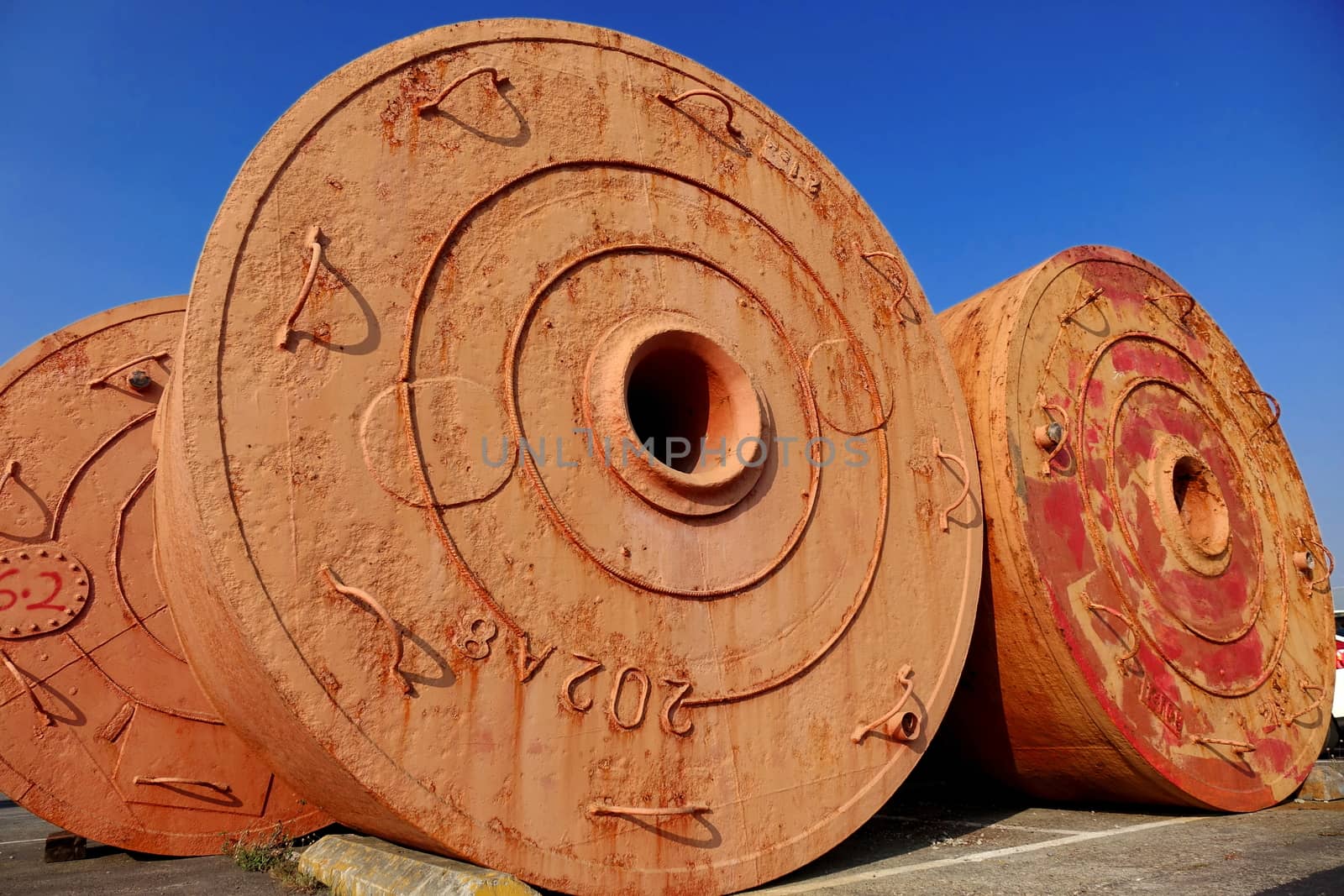 Large vintage mooring buoys are stored on dry land
