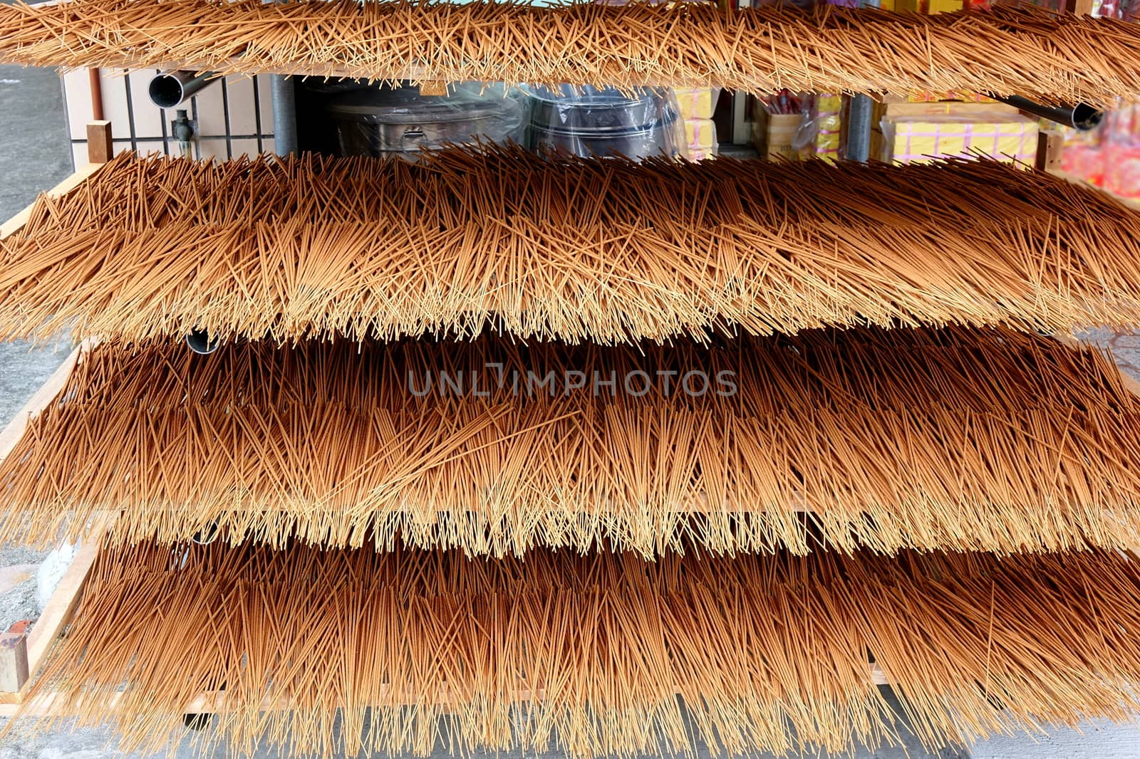 A store for religious artifacts dries incense sticks in the sun