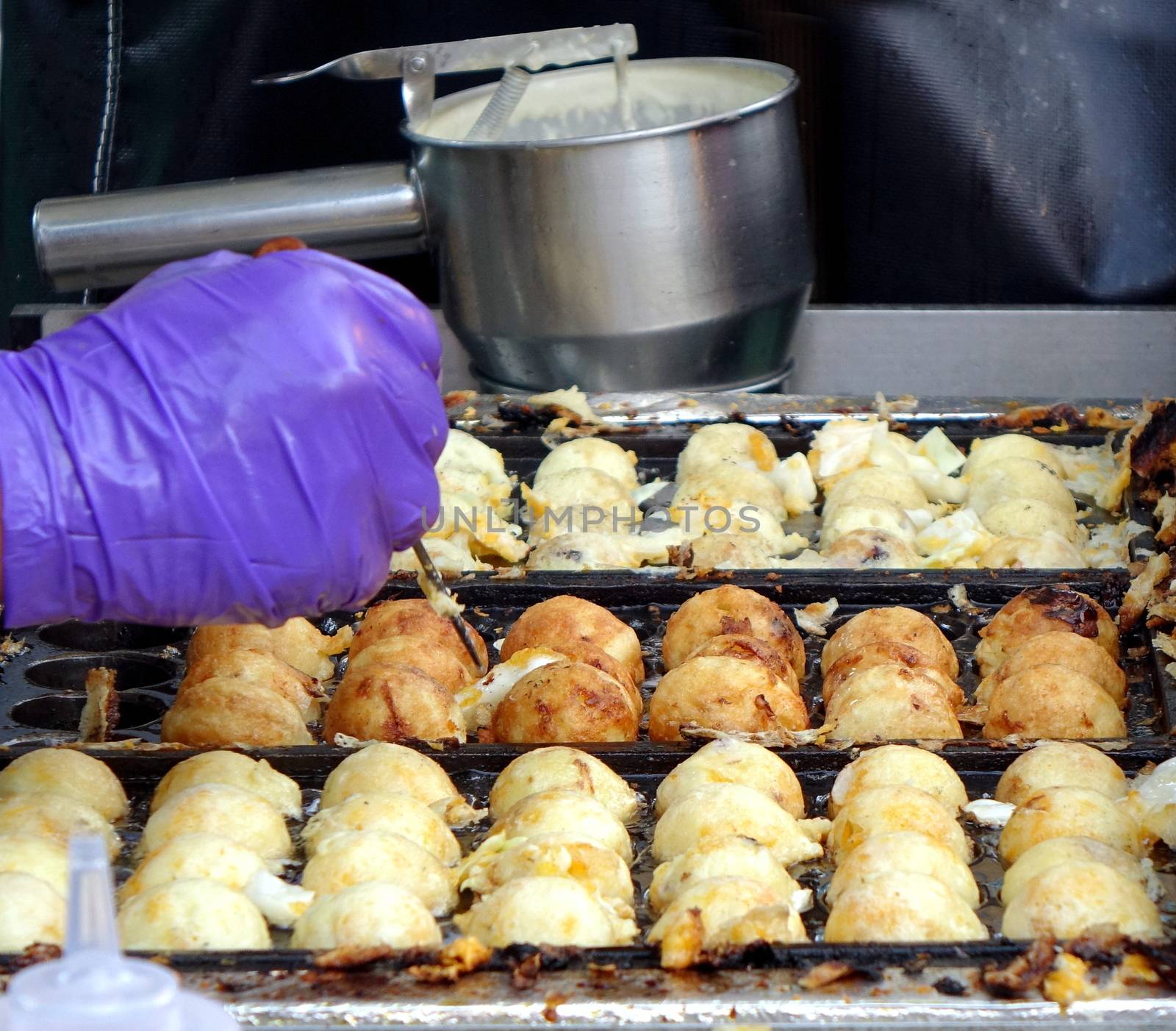 A street vendor cooks Japanese Takoyaki, or squid balls
