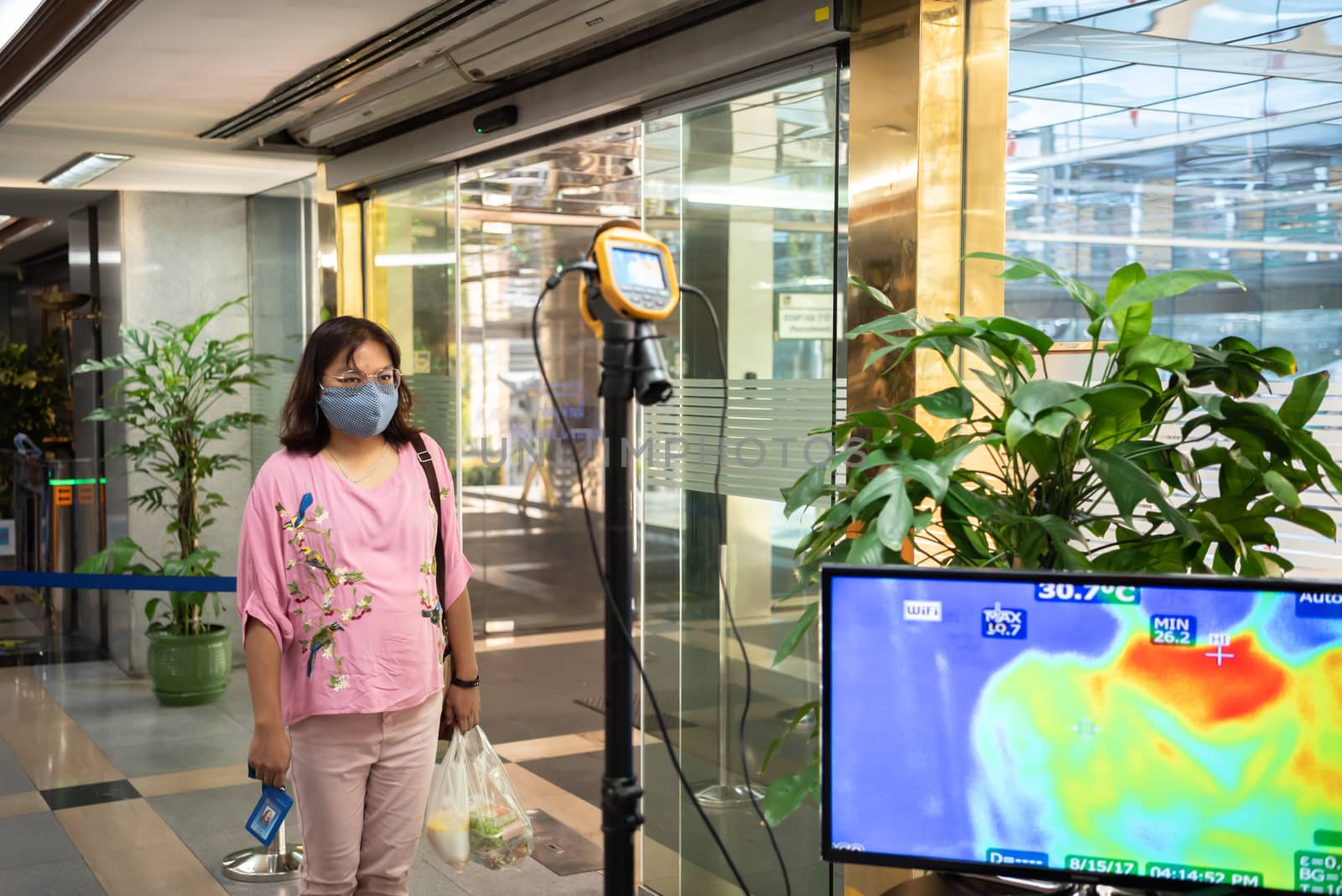 Bangkok, Thailand - March 24, 2020 : Unidentified people waiting body temperature check to access building for against epidemic flu covid19 or corona virus by thermoscan or infrared thermal camera
