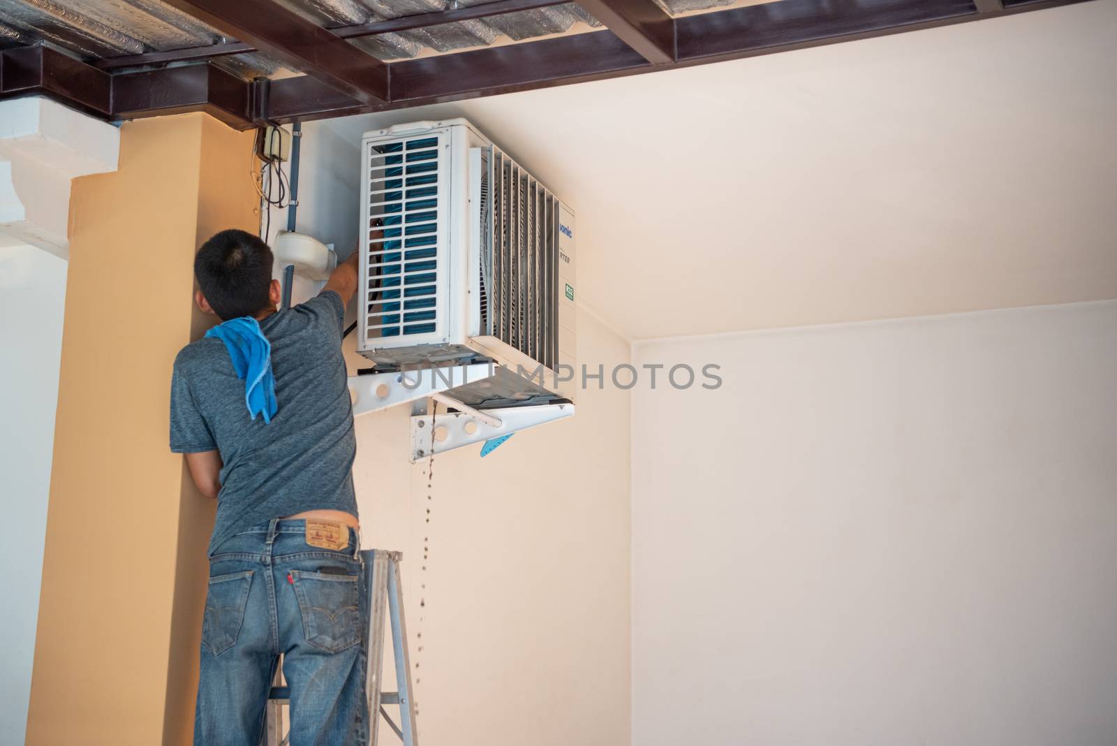 Bangkok, Thailand - January 12, 2020 : Unidentified worker to cleaning coil cooler of air conditioner by water for clean a dust on the wall in customer home when maintenance service