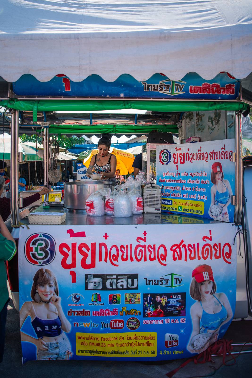 Samut Sakorn, Thailand - February 15, 2020 : Unidentified Asian sexy woman chef cooking a noodle soup with meat ball (kauy-tiew) for sale at Thai street food market or restaurant in Thailand