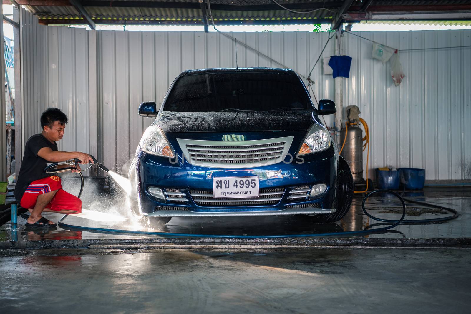 Bangkok, Thailand - February 16, 2020 : Unidentified car care staff cleaning (clean, wash, polish, wax and glass coating) the car (Car detailing) at car care shop in Bangkok Thailand