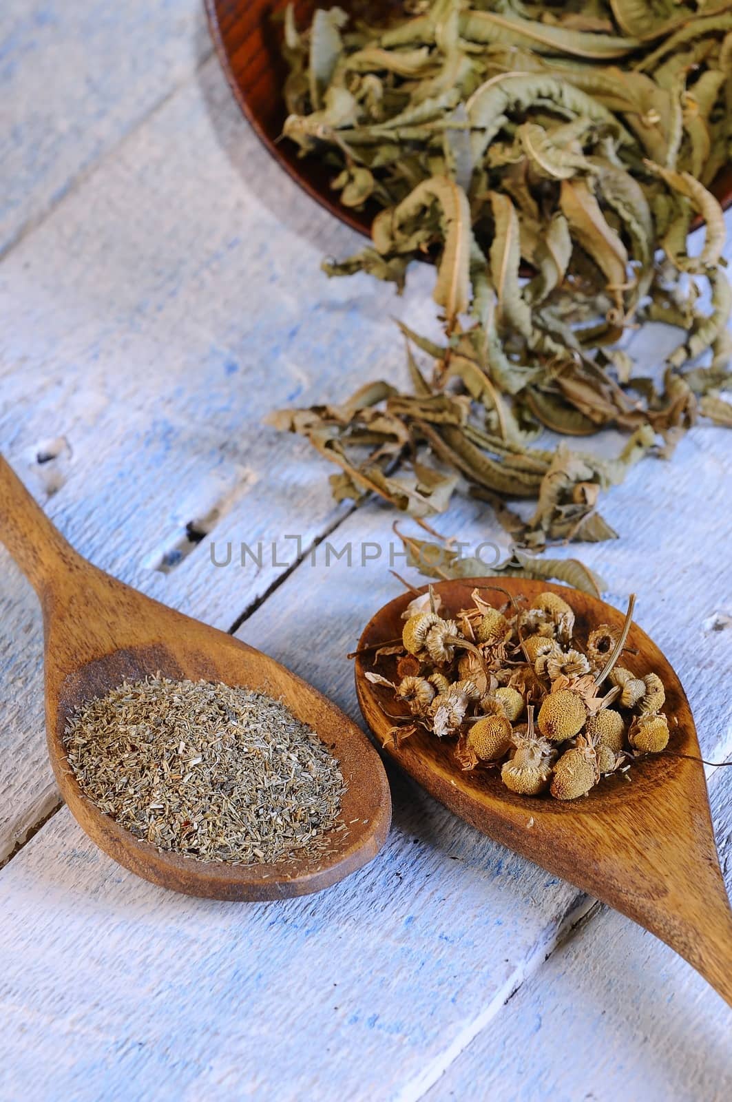 Chamomile and herbs on wooden table in the kitchen.